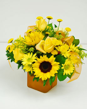 Bold and bright is the only way to describe this cube arrangement. Arranged in golden yellow cube are yellow roses, yellow sunflowers, yellow spray