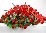 This casket spray designed with seven dozen red roses, white baby breath,mixed greens with stems of baby eucalyplus and matching red ribbons. This graceful spray pays tribute to your loved one.