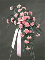 Standing spray holding 30 large carnations, baker fern, salal tips, tree fern and emerald leaves and ribbons, on a 60
