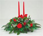 No holiday table is complete without the warm glow of burning candles. Our “holiday Lights” centerpiece is sure to bring that glow. This twin candle centerpiece is filled with the colors of the holidays. Red carnations with mixed holiday evergreens, red r