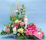 This striking design is arranged with a ceramic statue of the Virgin Mary surrounded by a mix of pink stargazers, pink carnations, green hydrangeas, white daisies, with pink larkspur, baby breath and mixed greens. When words fail us let flowers speak fo