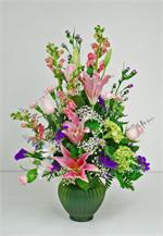 Offer comfort in their time of sorrow with our beautiful sympathy arrangement fresh pastel blooms of green hydrangea, pink oriental stargazers, pink carnations with pink roses purple statice, white daisies, and pink larkspur with mixed greens and million 
