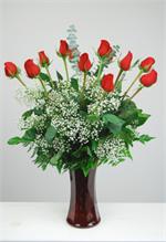 Wild about you is not just another rose arrangement. This design is made with twelve premium long stem red rose with million star baby breath, mixed greenery and baby blue eucalyptus. The ruby red designer glass vase complete the design. It’s a spe